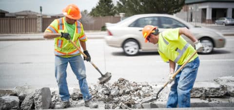 Two workers working on concrete road
