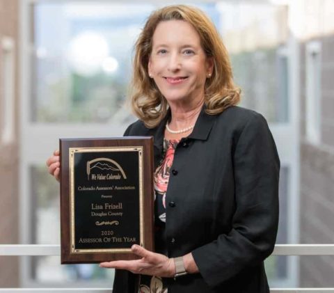 Assessor Lisa Frizell holding Assessor of the Year award plaque