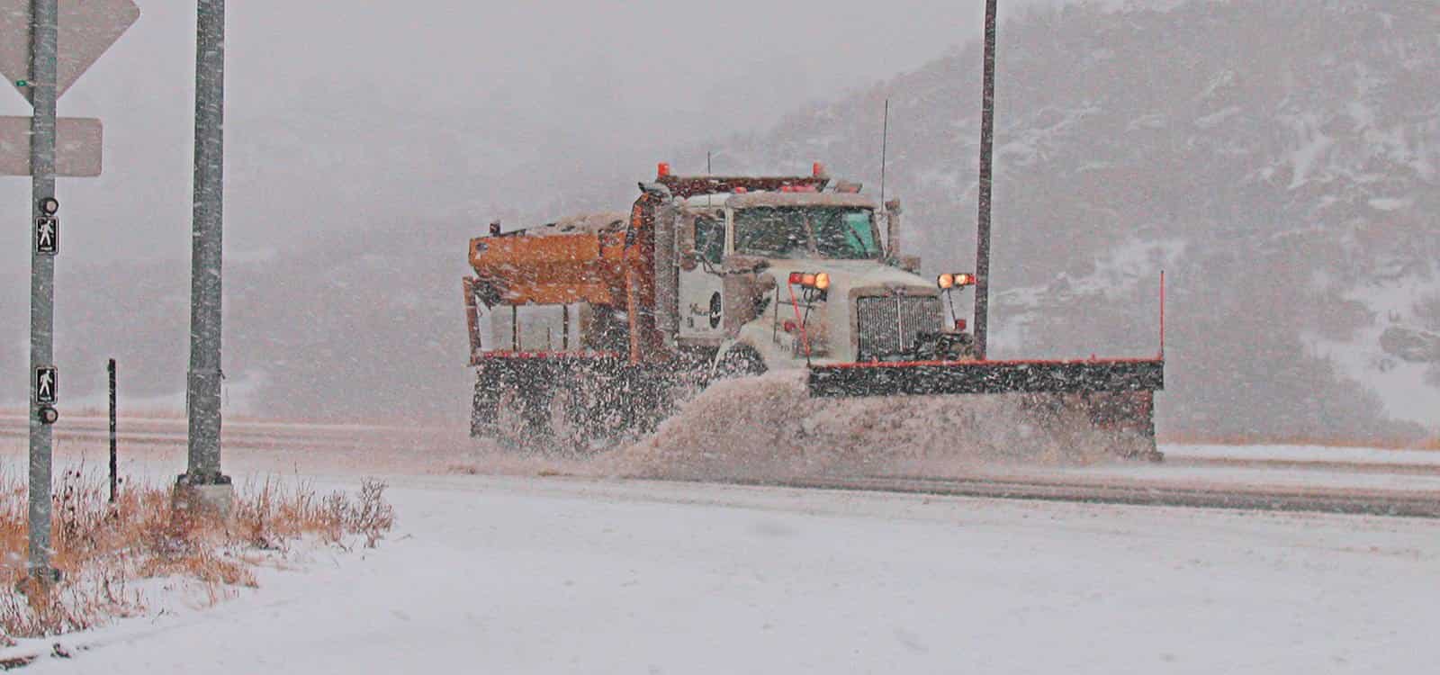 Douglas County snow plow in with blade on roadway during snow storm